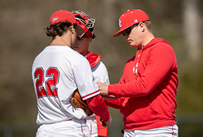 Baseball coach talking to players.