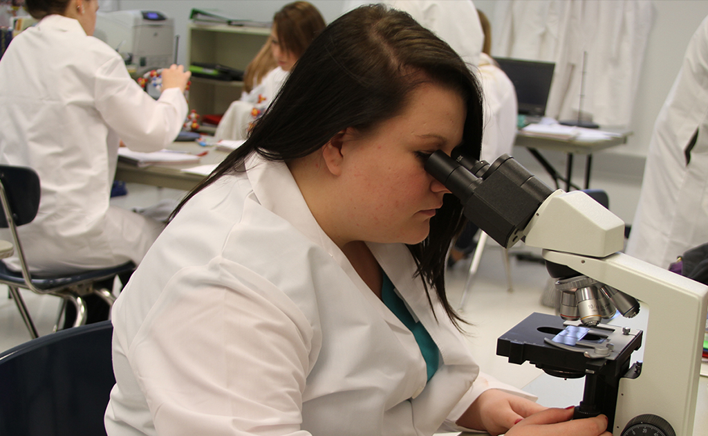 Student looking in microscope.