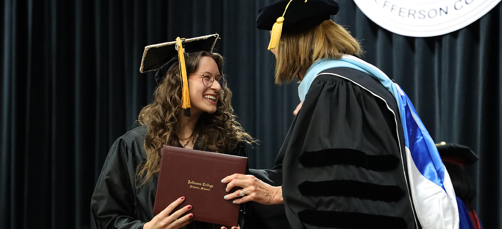 Female student receiving diploma from president.