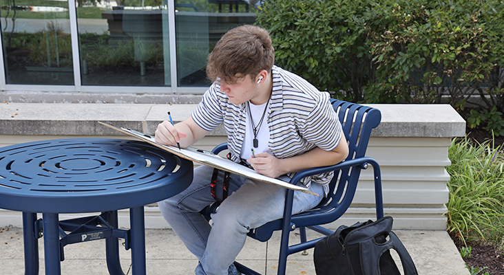 Art student drawing outside.