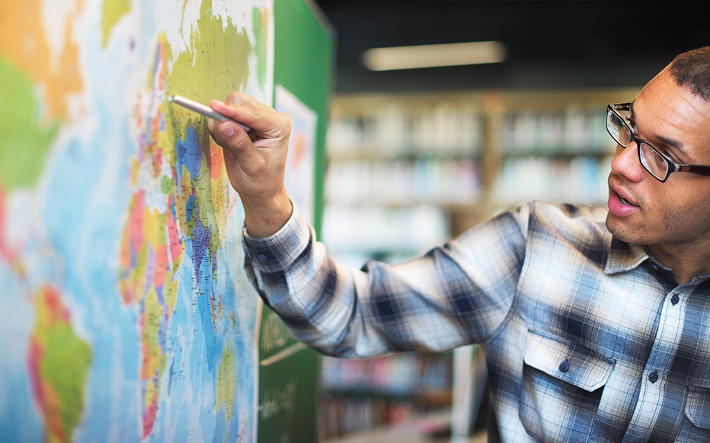 Teacher pointing at map.