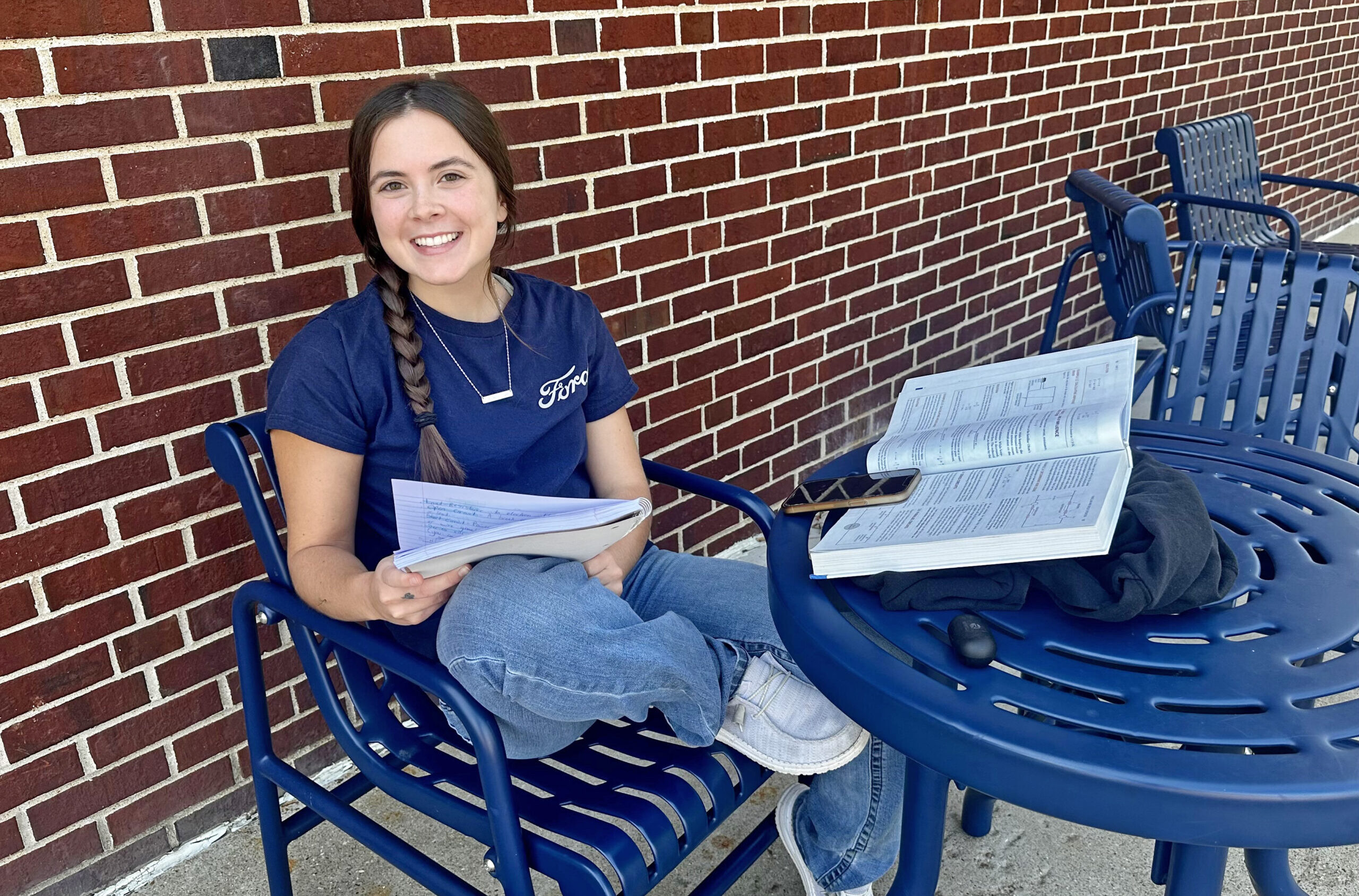 Student sitting outside buidling.